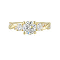 Gorgeous three stone ring features a round solitaire with one smaller diamond on either side. All of this sits a top a criss cross band with playful flow of diamond is a perfect choice.